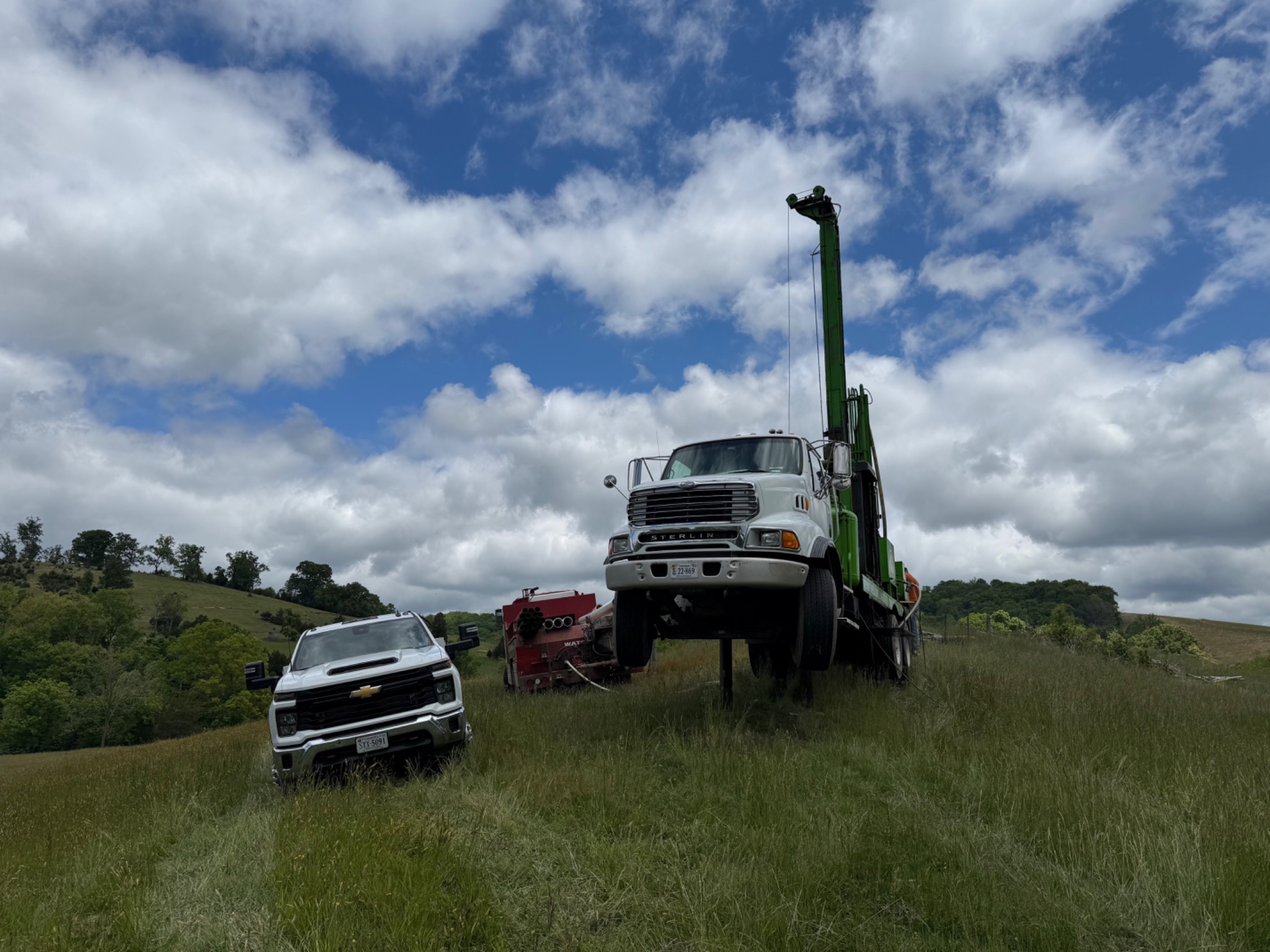 Water well drilling rig at a hillside job site